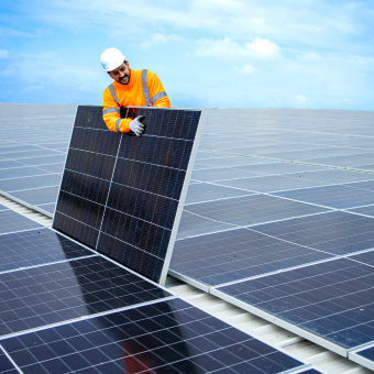 Instalador solar segurando placa solar