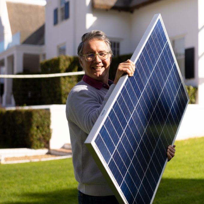 Homem segurando placa solar